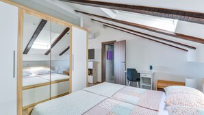 Un dormitorio con cama, escritorio y armario.