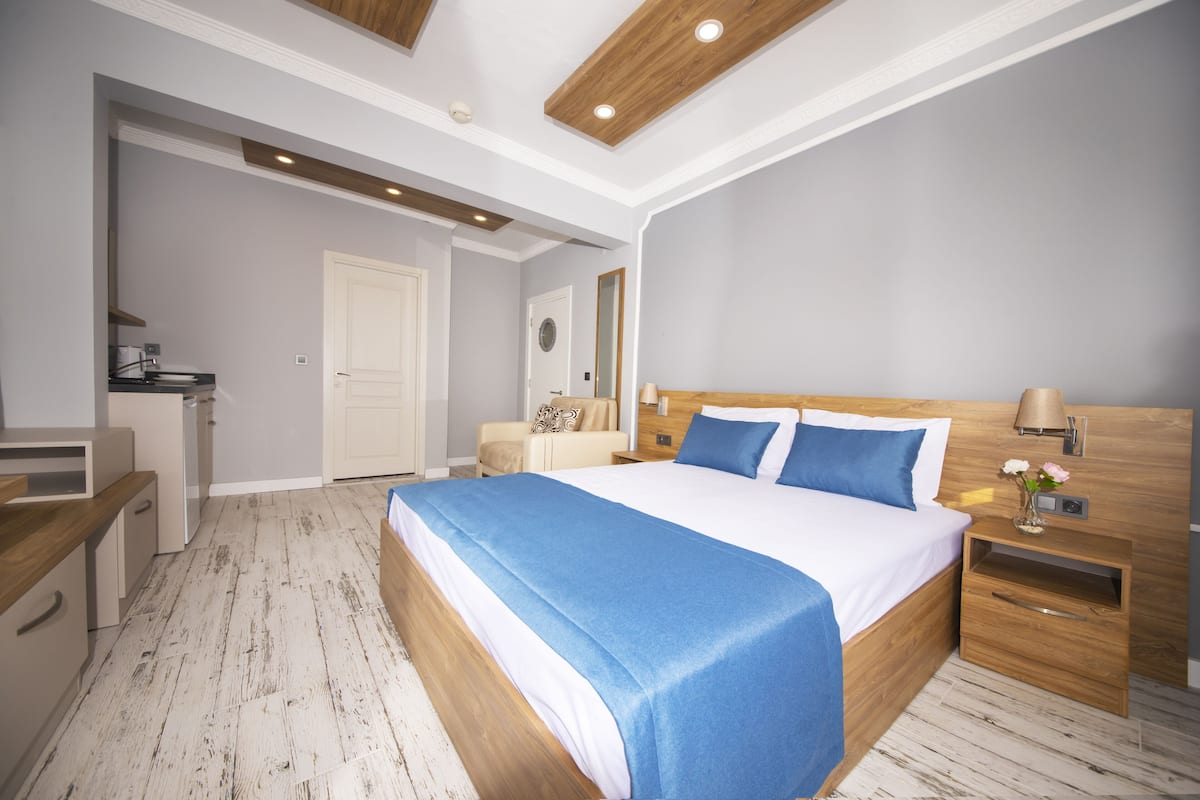 Ein modernes Schlafzimmer mit einem großen Bett, einem Holz-Kopfteil, Nachttischen und einem eingebauten Kleiderschrank.