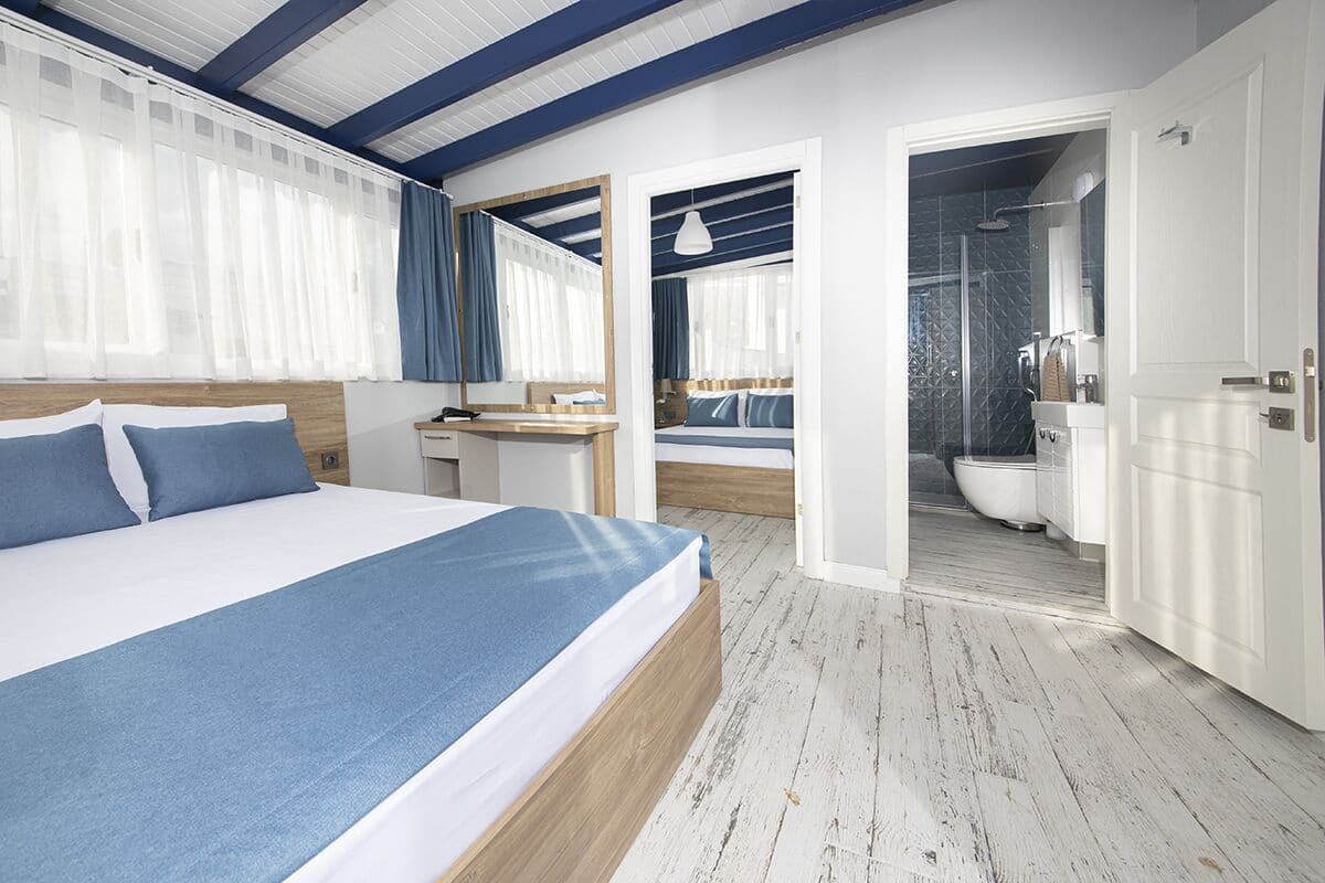 Ein modernes Hotelzimmer mit einem großen Bett, einem Schreibtisch, einer Duschkabine und einem Badezimmer.