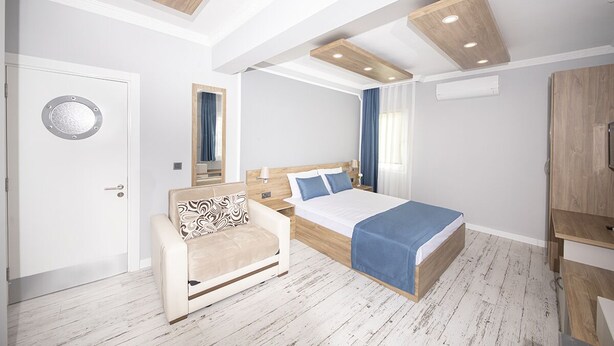 Un dormitorio moderno con cama, sofá, espejo y armario.