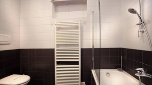 A bathroom with a toilet, a bathtub, and a shower.