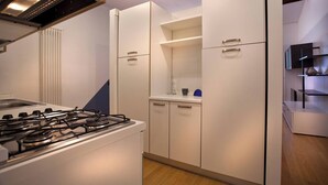 A modern kitchen with a gas stove, white cabinets, and a built-in oven.