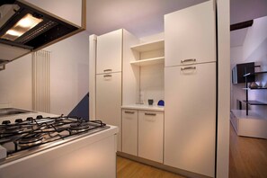 A modern kitchen with a gas stove, white cabinets, and a built-in oven.
