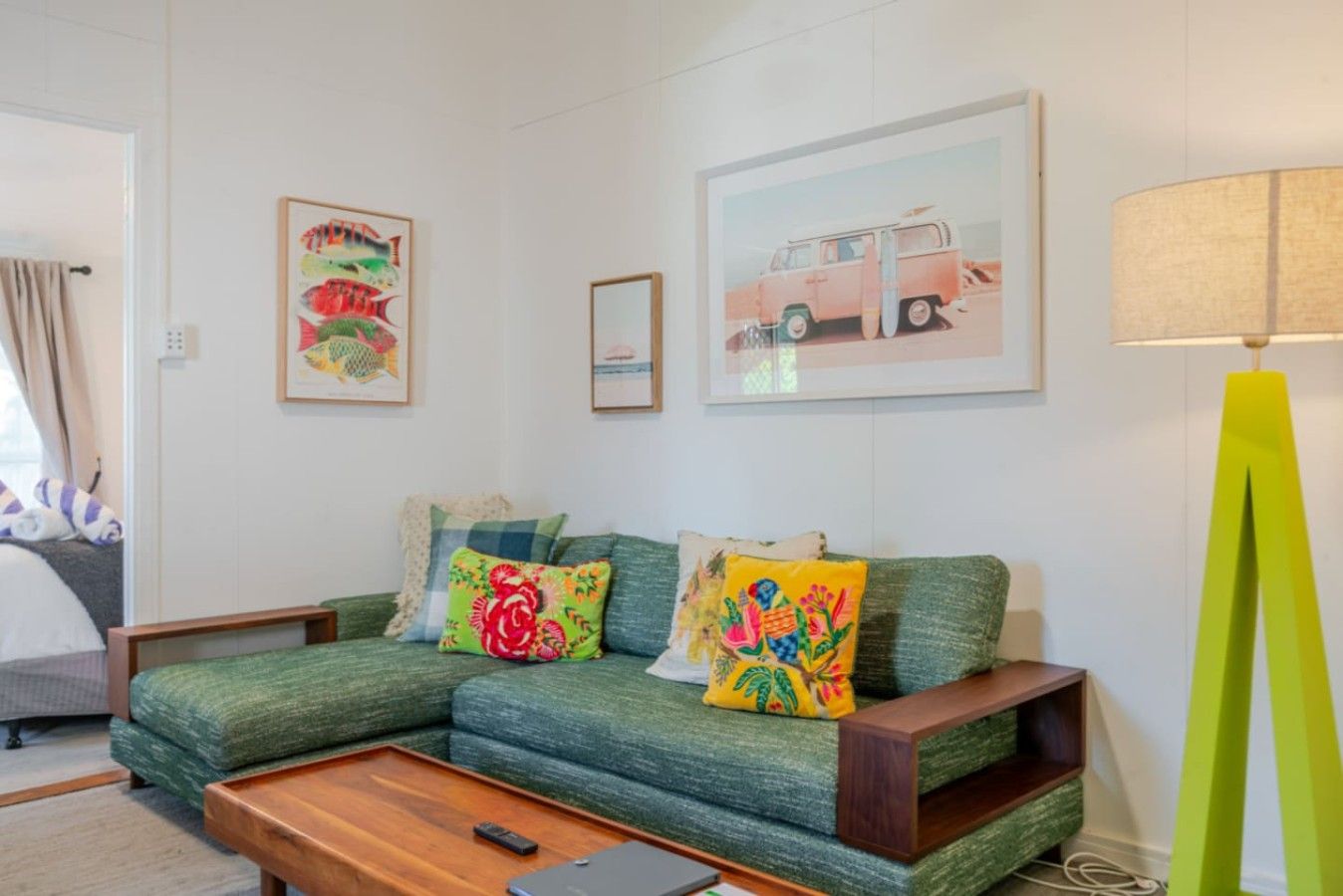 A living room with a green sofa, a wooden coffee table, and a lamp.