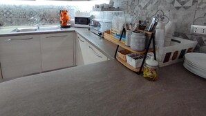 A kitchen with a microwave, toaster, and various kitchen utensils. - Dolcesosta B&B (Pulsano)