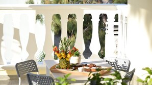 A terrace with a table set for breakfast, including a pineapple centerpiece, a potted plant, and a tray of pastries. - Dolcesosta B&B (Pulsano)