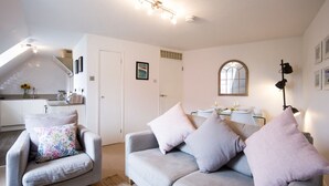 Una sala de estar moderna con un sofá gris, un sillón a juego y un comedor con una mesa y sillas.