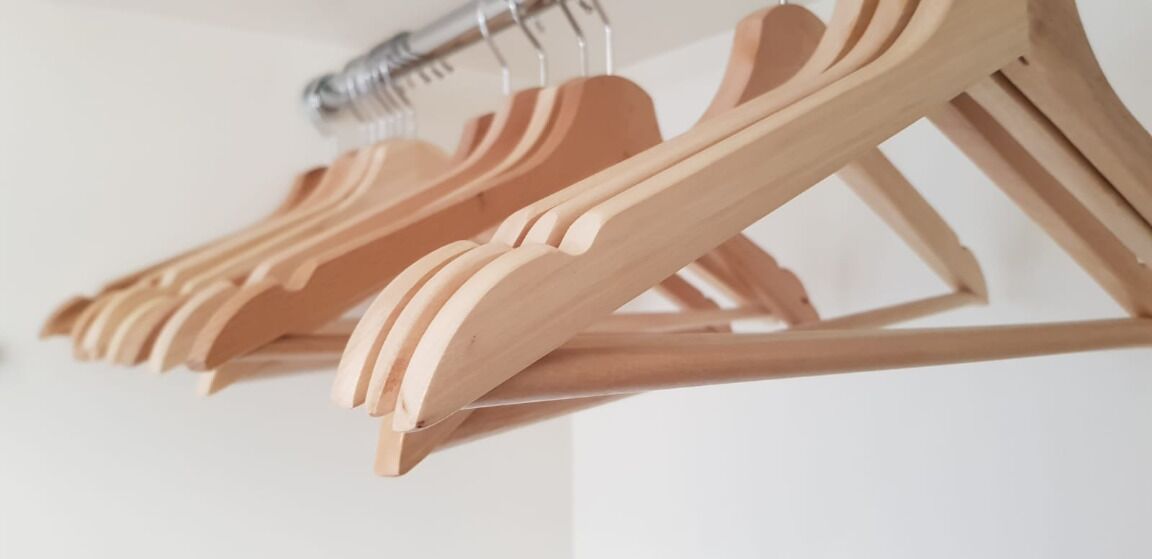 Una fila di grucce di legno su una parete.