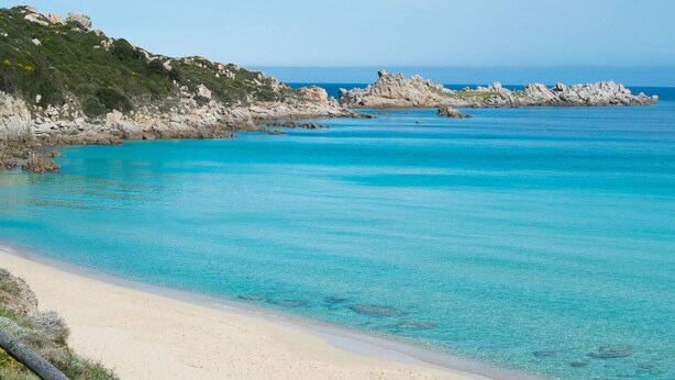A beach with clear turquoise water, a sandy shore, and rocky outcrops. - Holiday House Palau (Palau)