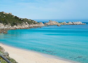 A beach with clear turquoise water, a sandy shore, and rocky outcrops. - Holiday House Palau (Palau)