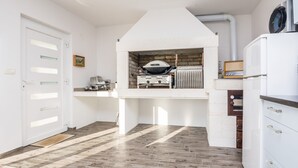A compact kitchen with a built-in oven, a microwave, and a refrigerator. - Apartments Olujic (Vir)