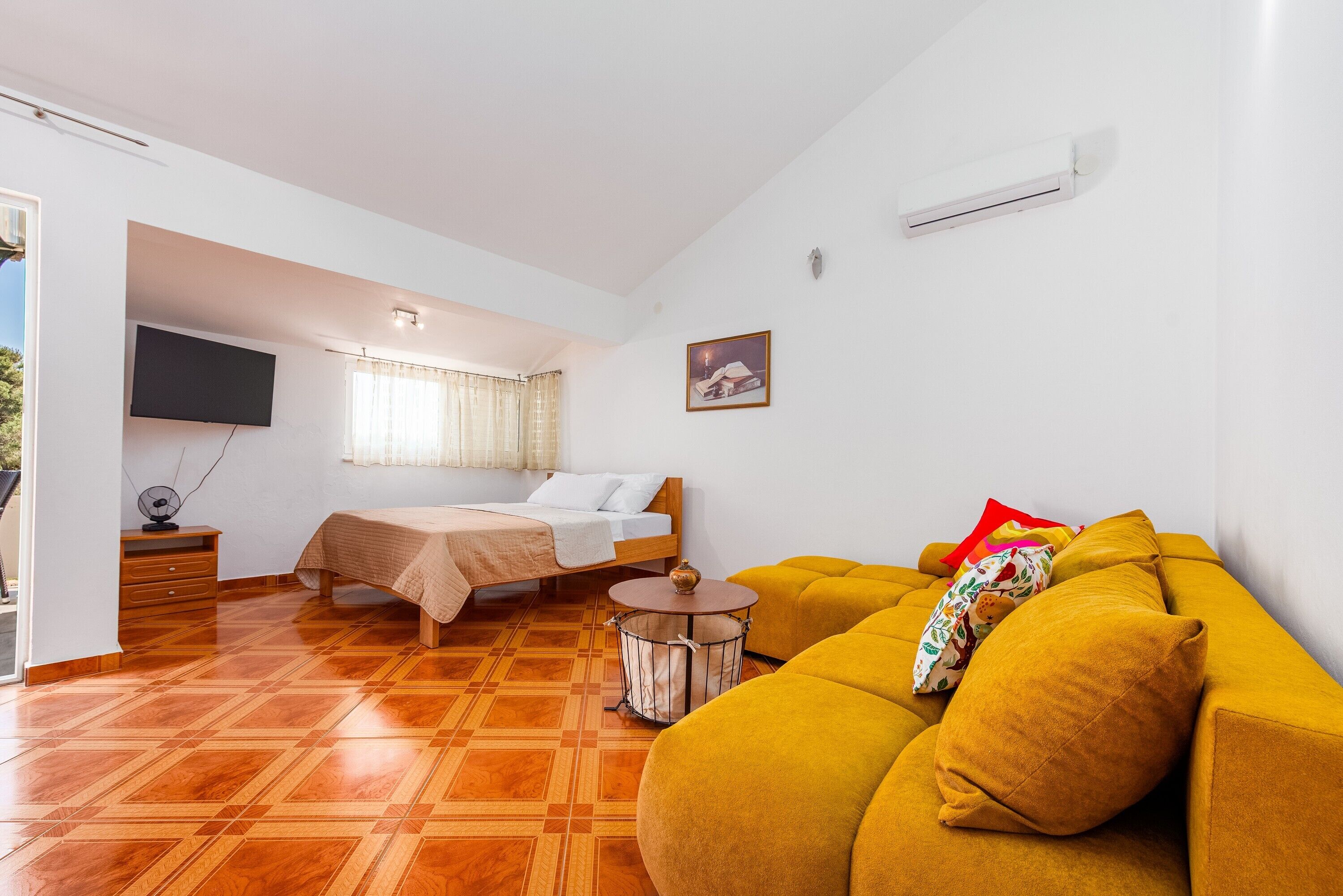 A room with a bed, a sofa, a TV, and a small table.