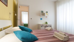 A hotel room with a bed, pillows, a desk, and a chair. - Casa Vacanza Valle (Sperlonga)