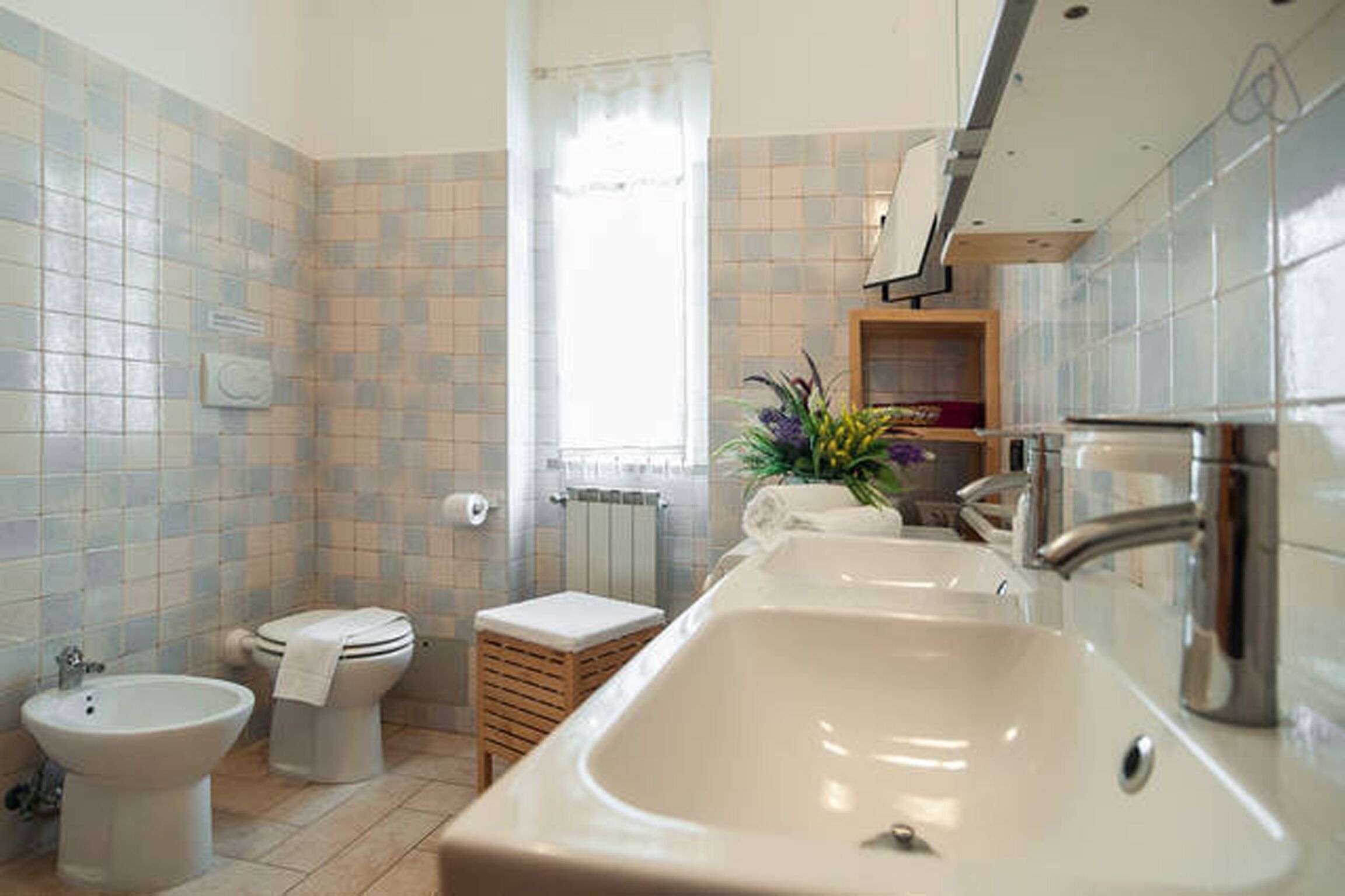 Een badkamer met een bad, toilet, bidet en wastafel.