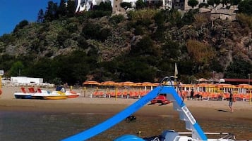 En la playa, arena blanca, sillas reclinables de playa, sombrillas