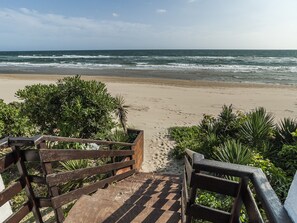 A wooden staircase leading to a sandy beach with ocean waves in the background. - Casa Vacanza Maresol8 (Sperlonga)