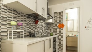 A modern kitchen with a white countertop, stainless steel sink, and a patterned backsplash. - Casa Vacanza Cariddi Loft (Sperlonga)