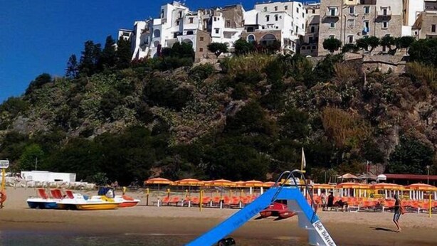 A boat on a beach with a mountainous backdrop. - Casa Vacanza Mare Verde (Sperlonga)