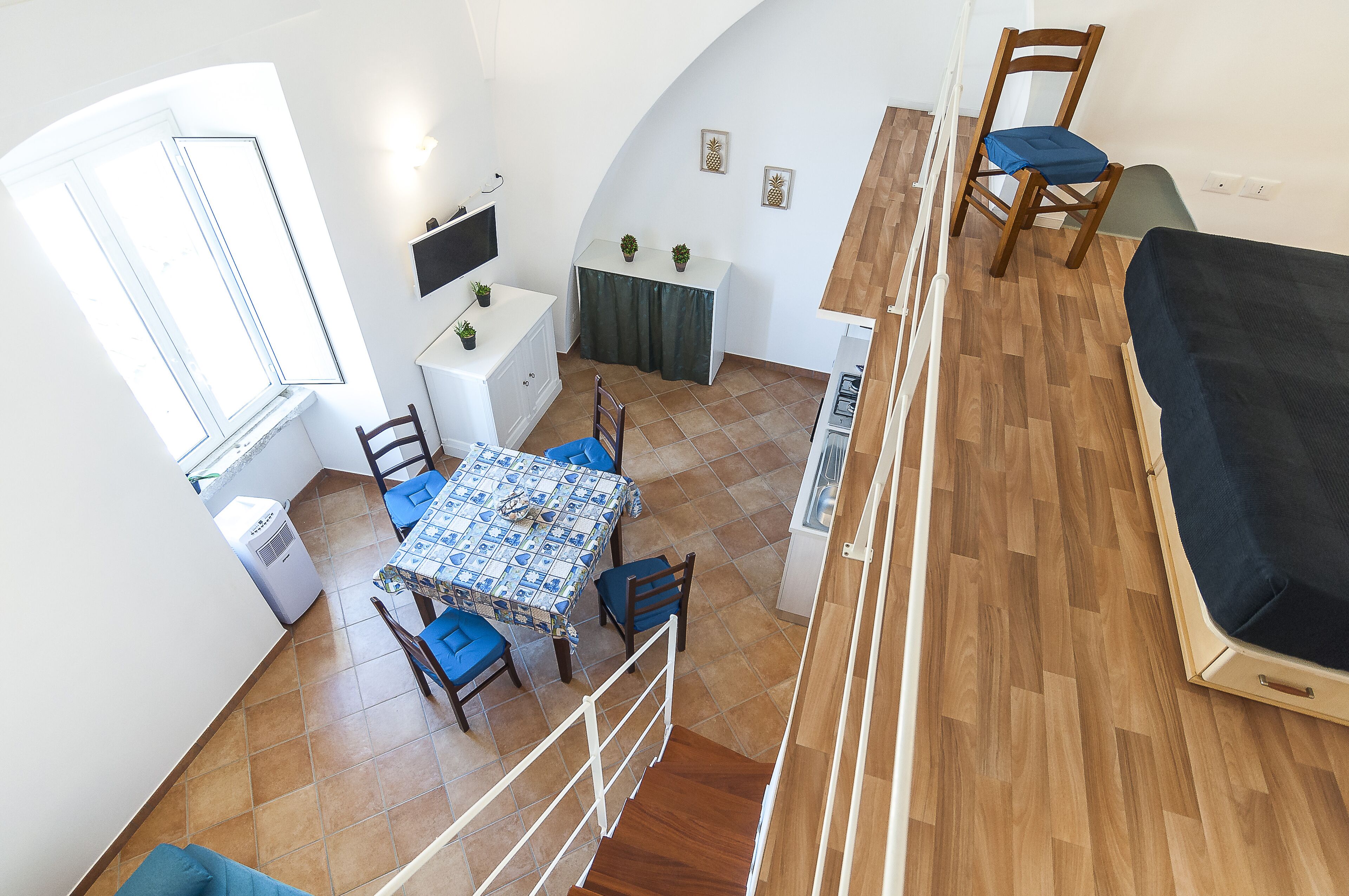 Un espace de vie compact comprenant un coin repas, une petite cuisine et un espace nuit.