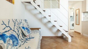A staircase with white railings and wooden steps leading to an upper level. - Casa Vacanza Madonnella 12 (Sperlonga)