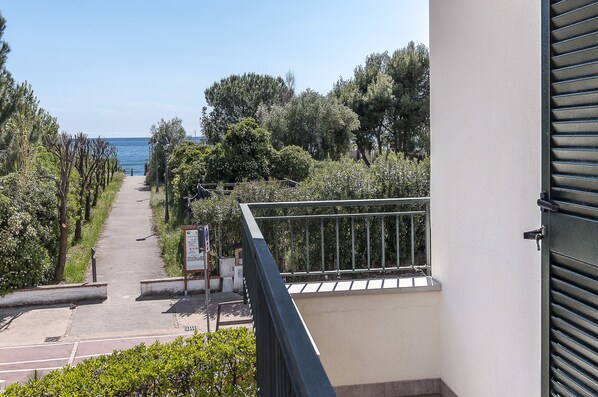 A pathway leading to a beach, surrounded by greenery and a railing. - Casa Vacanza Minerva (Sperlonga)