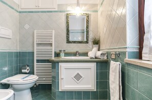 A bathroom with a toilet, sink, and mirror. - Casa Vacanza Minerva (Sperlonga)