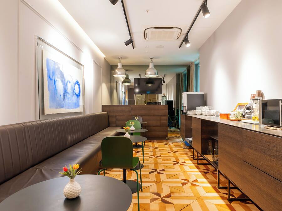 Een modern restaurant met een lange toonbank, meerdere tafels en een zithoek met een bank.
