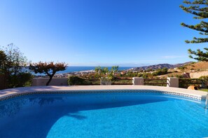 Una piscina con vistas despejadas al paisaje costero.