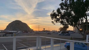 A parking lot with cars and a mountain in the background.