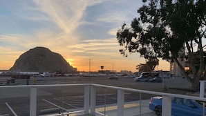 Un parking rempli de voitures, avec une montagne en arrière-plan.