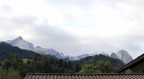 Cordillera con un valle boscoso y un edificio con techo de tejas.