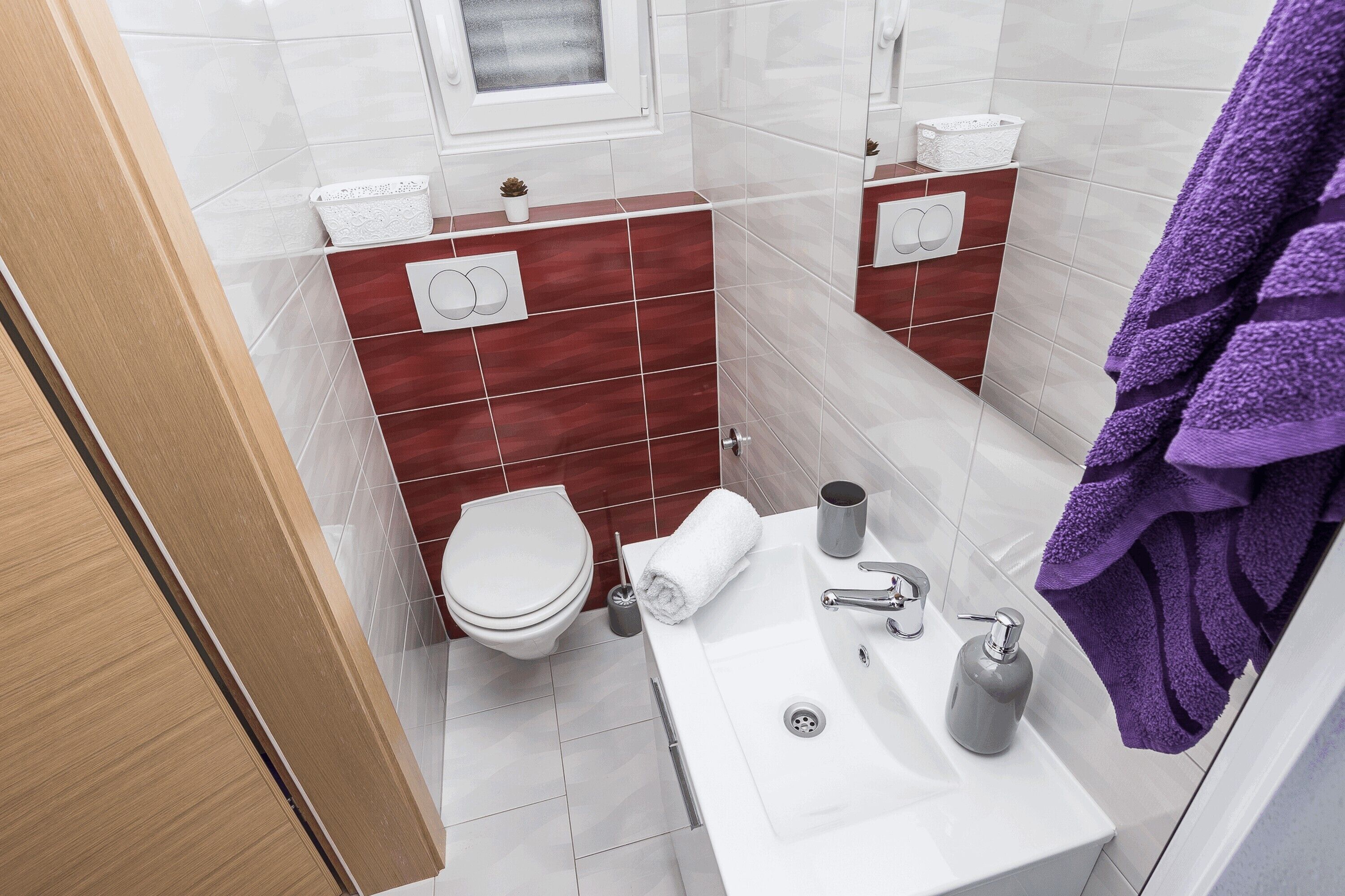 Ein Badezimmer mit einem weißen Waschbecken, einer Toilette und einem Spiegel.