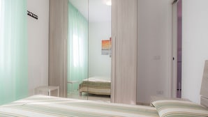 Um quarto com uma cama, uma cadeira e um guarda-roupa.