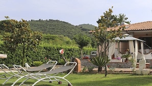 Uma villa com jardim, área de estar ao ar livre e vista para as colinas.