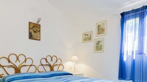 A bedroom with a bed, two bedside tables, and wall-mounted lamps. - Appartamento Casa Plein Air  (Portoferraio)