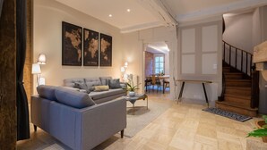Una sala de estar moderna con un sofá gris, una mesa de centro y un gran mapa del mundo en la pared.