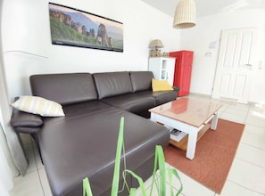 A modern living room with a black leather sofa, a wooden coffee table, and a red refrigerator. - Sehr Hell und Freundlich Gestaltete Ferienwohnung für 2 bis 4 Personen mit Wlan (Norddeich)
