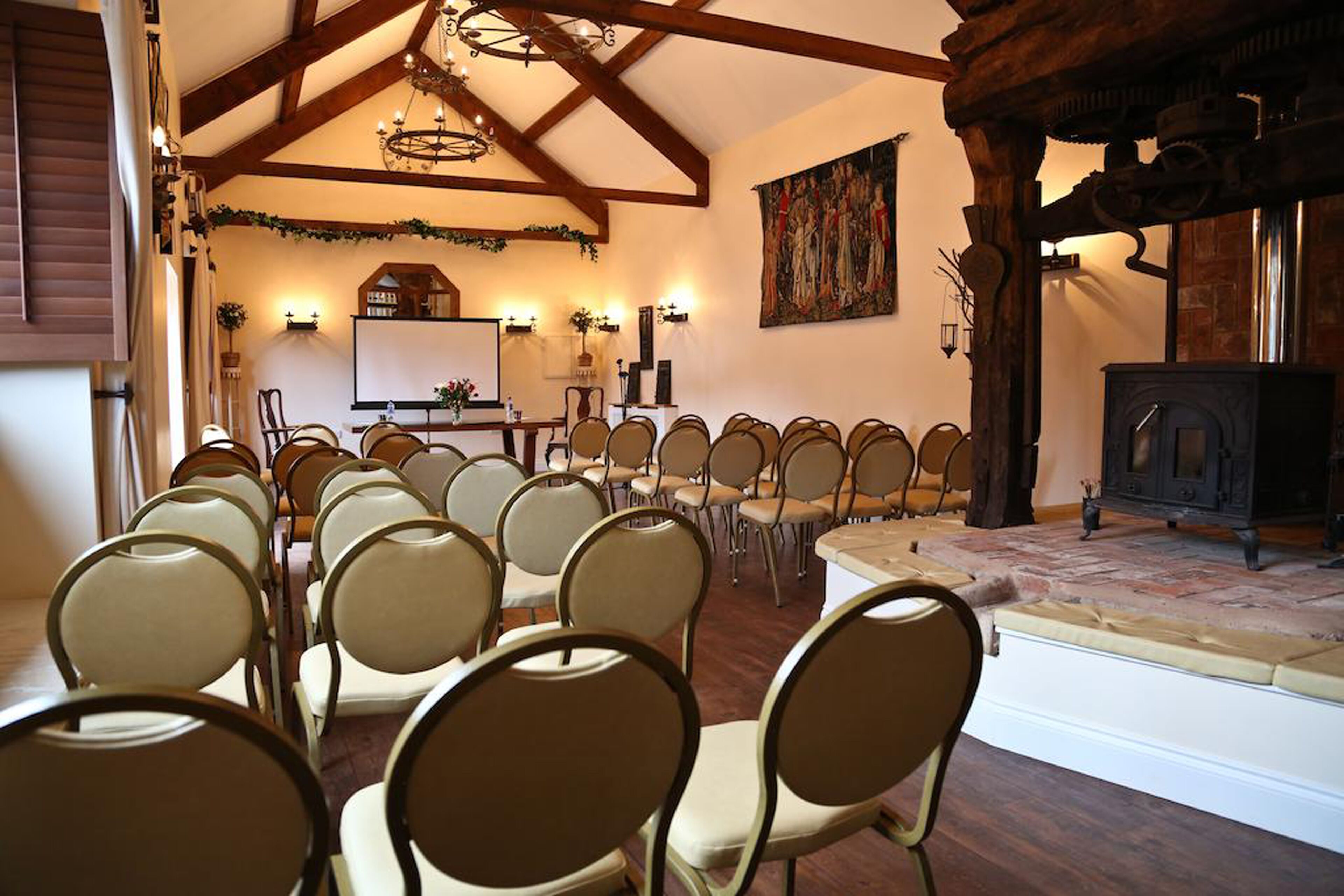 A conference room with rows of chairs facing a stage with a fireplace.