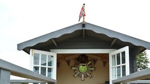 A wooden deck leading to a covered seating area with a flag on top. - Muddifords Court (Tiverton)