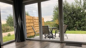Una habitación con un amplio ventanal corredero que da a un patio exterior.