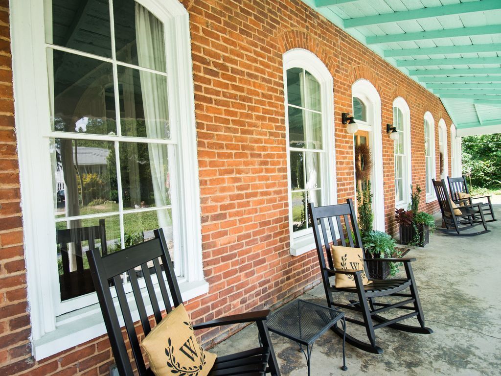 A brick building with arched windows and outdoor seating.