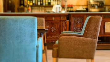 A bar area with wooden furniture and a variety of bottles.