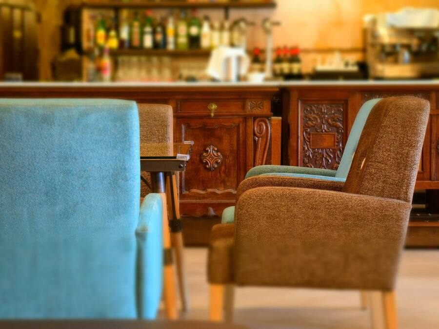 A bar area with wooden furniture and a variety of bottles.