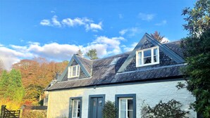 A two-story house with a gabled roof, white exterior walls, and a small front porch. - Darroch Beag Cottage, nearby Loch Fyne, peaceful location (St Catherines, Cairndow)