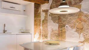Une cuisine moderne avec des meubles blancs, une cuisinière encastrée et un mur d’accent en pierre.
