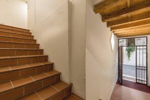 A staircase with terracotta steps leading to a wooden ceiling.