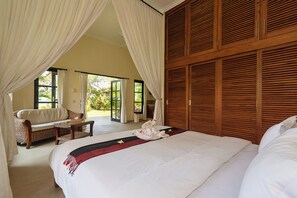 Una camera da letto con un letto grande, un divano, un tavolino e vista sull'esterno.
