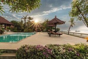 Area piscina con gazebo, poltrona relax e vista sul mare.
