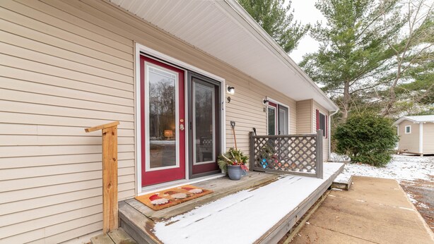 A single-story house with a red door and a small porch.