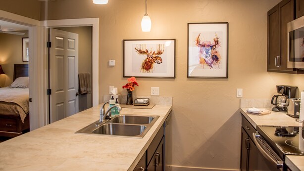 A modern kitchen with a large island, stainless steel appliances, and framed artwork on the wall.